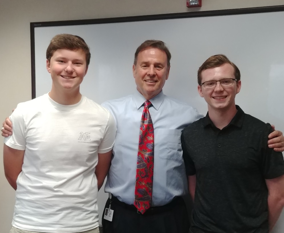 a man with his arms around two young men